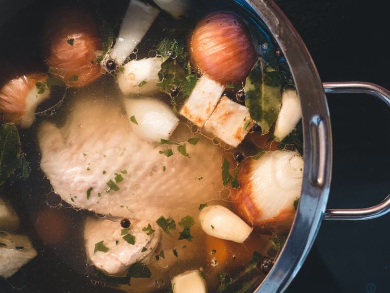 a pot of chicken soup with vegetables